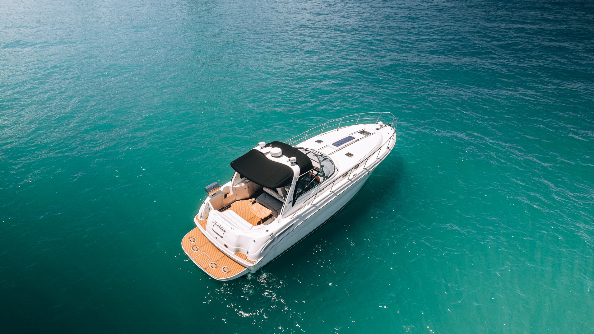 Aerial view of a white yacht cruising on turquoise water